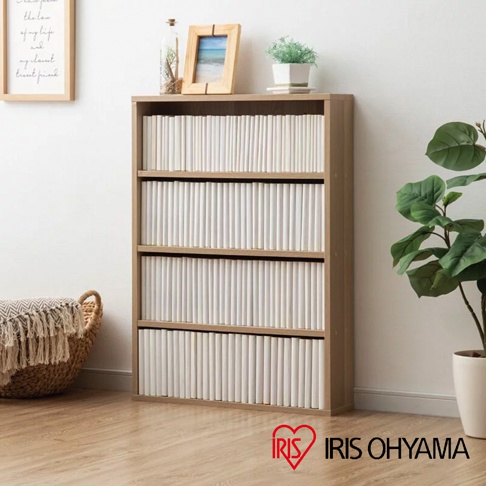 淺木色漫畫收納書櫃 CORK-8460，四層開放式設計，每層擺滿白色漫畫書。書櫃旁為編織籃和綠植裝飾。