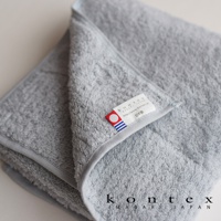 一張淺灰色極柔蓬鬆的今治大毛巾，帶有品牌標籤，標籤上印有「kontex imabari japan」字樣和日本國旗圖案。