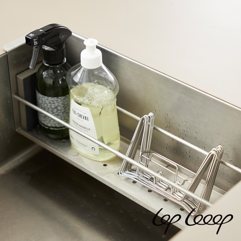 不鏽鋼廚房水槽瀝水架，架上放有一瓶綠色清潔噴霧瓶和一瓶透明洗碗精瓶，右側有一個銀色不鏽鋼餐具瀝水籃。