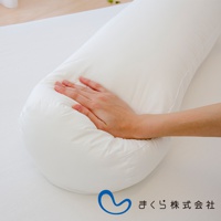 一張白色的零負擔速眠萬用圓柱夾腿枕，枕頭呈現圓柱形，表面為光滑的布料，一隻手正按壓在枕頭上，展示其柔軟度。