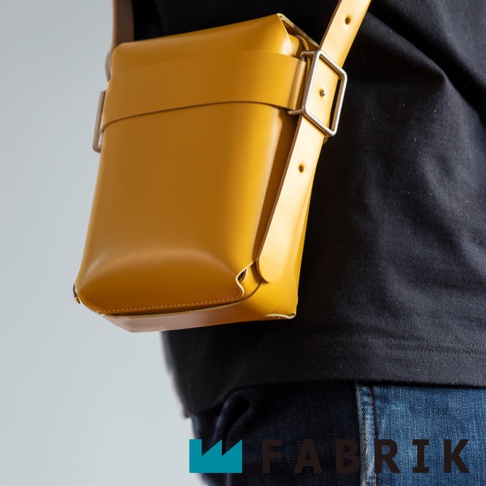 FABRIK 黃色皮革迷你斜背包，配有銀色金屬扣環及可拆式背帶，以簡約現代的風格呈現。
