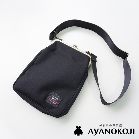 AYANOKOJI Sarei 機能布直式口金斜背包，以黑色布料製作，配有古銅色金屬開合和可調節式背帶。