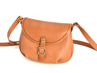 一個淺棕色、皮革材質的馬鞍包，帶有可調節的肩帶和金色搭扣。