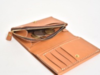 職人手作皮革中型雙折短夾，淺棕色皮革，拉鍊零錢袋內有硬幣，錢夾內有卡槽和壓扣。