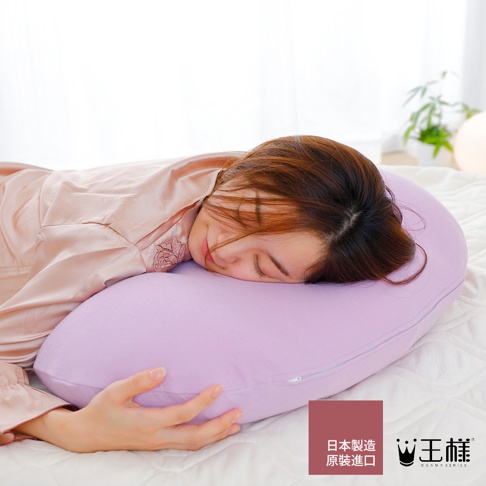 一位女性趴睡在淡紫色舒肩枕上，枕頭材質柔軟，帶有拉鍊。