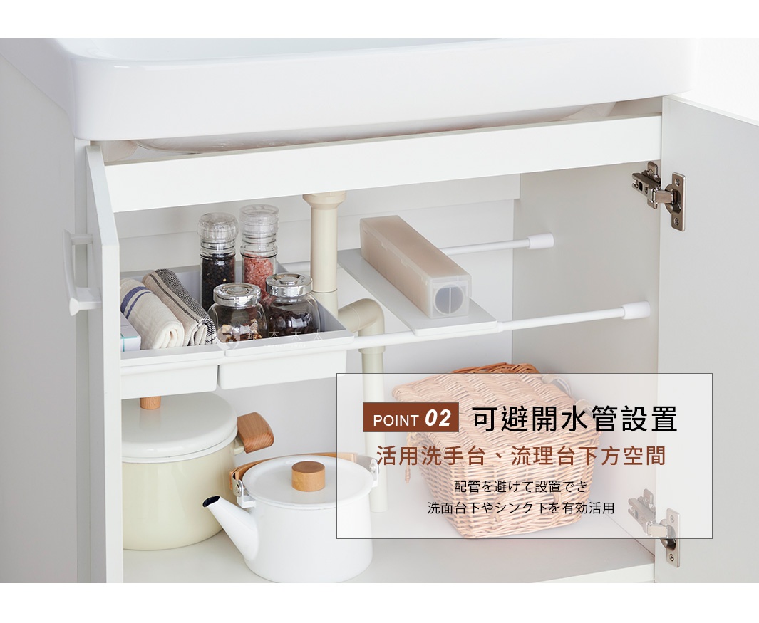 白色櫃體內的收納空間，利用兩根白色伸縮桿支撐一片長方形白色置物板，巧妙避開中央的排水管，板上放置了廚房用品與收納盒，下方櫃底則擺放了鍋具與編織籃，展示如何有效利用流理台下方的畸零空間。