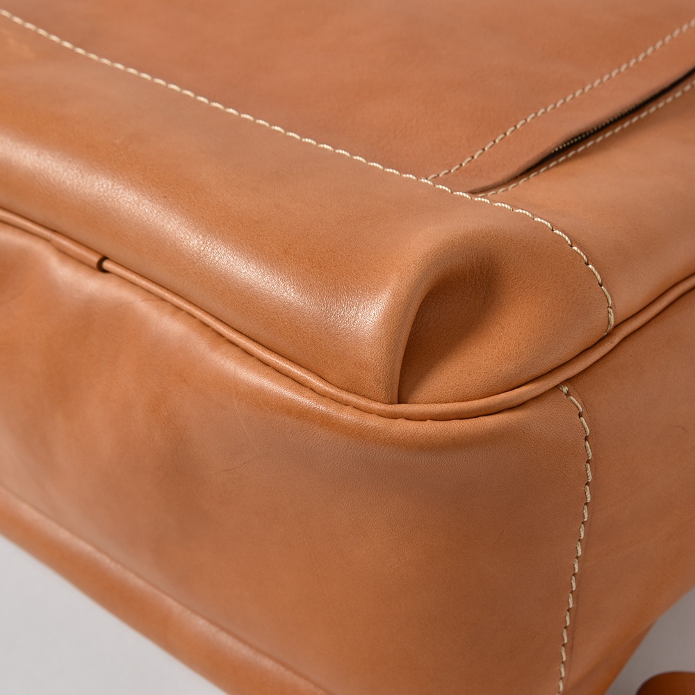 職人手作皮革多功能後背包 R-21，展示焦糖棕色光滑皮革材質，車縫線清晰，包角圓潤。