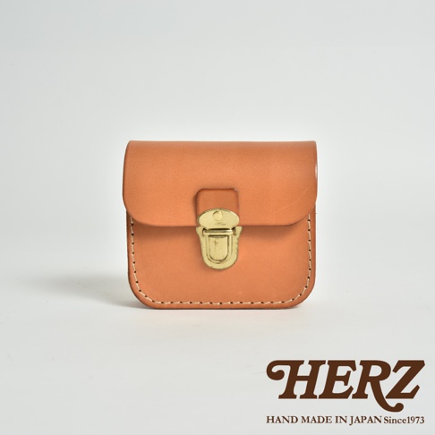 棕褐色皮革製成的經典腰包，帶有復古黃銅插銷和縫線細節。