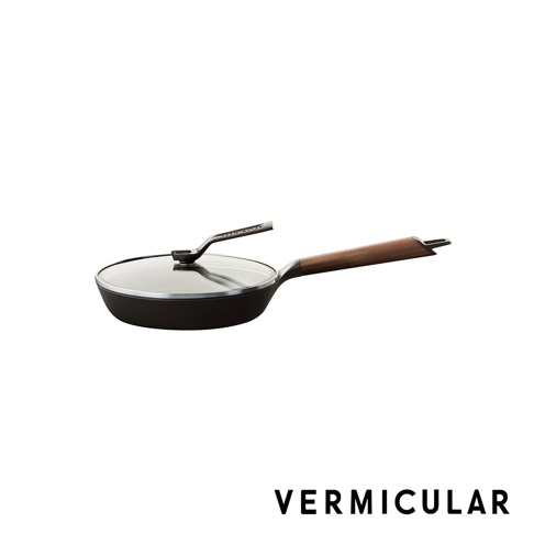 日本製琺瑯鑄鐵平底鍋，配有透明玻璃鍋蓋及木質手柄，鍋身為黑色，手柄為木紋色。