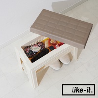 米白色塑膠製玄關穿鞋收納椅，上方置有棕色格紋椅蓋，內部收納有鞋油罐、鞋刷、鞋油瓶及一雙米色帆布鞋。