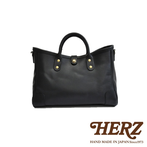 黑色職人手作皮革大容量托特包 T-146，包身線條簡潔，配有雙提把與金色金屬扣，材質為光滑皮革，質感佳。