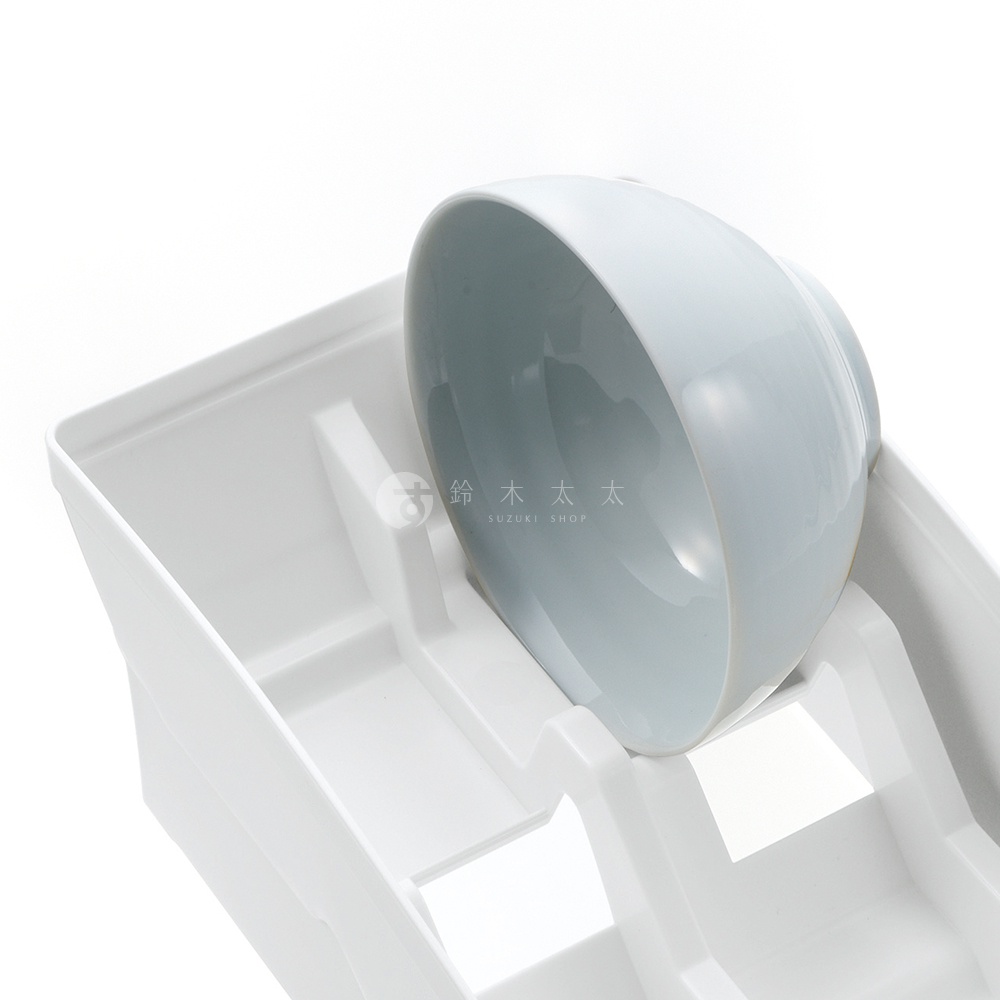 白色塑膠櫥櫃式餐碗收納架，架上有兩個碗槽，一個淺藍色碗正放置在其中一個槽內。