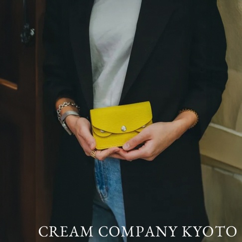 鮮黃色皮革手作零錢包，帶有銀色金屬釦，簡約設計，適合隨身攜帶。