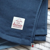 藍色紗布毛巾，表面紋理清晰，左側有標籤，標示「made in Japan」和「hiorie」，材質輕薄透氣，邊緣有縫製。