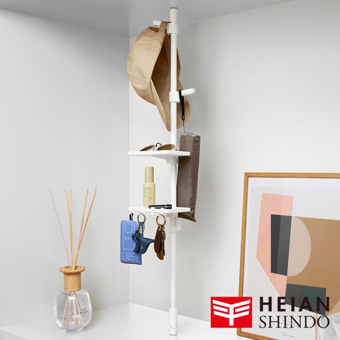 白色直撐款伸縮桿，上方掛有卡其色帽子，中間層板擺放著太陽眼鏡、髮妝噴霧和雨傘，下方掛有藍色與棕色鑰匙圈。