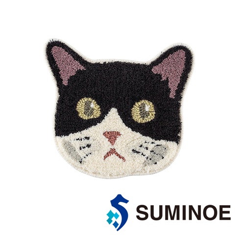 這是一款由 SUMINOE 品牌設計的 NEKOKAO 貓咪造型椅墊，外觀呈現黑白雙色的貓咪頭部剪影，採用細緻的簇絨織法製作，擁有粉紅色的耳朵內側與鼻頭細節，金黃色的雙眼炯炯有神，底部飾有 SUMINOE 品牌標誌。