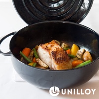 黑色琺瑯鑄鐵鍋內盛有烤肉塊及胡蘿蔔、四季豆、馬鈴薯等燉菜。