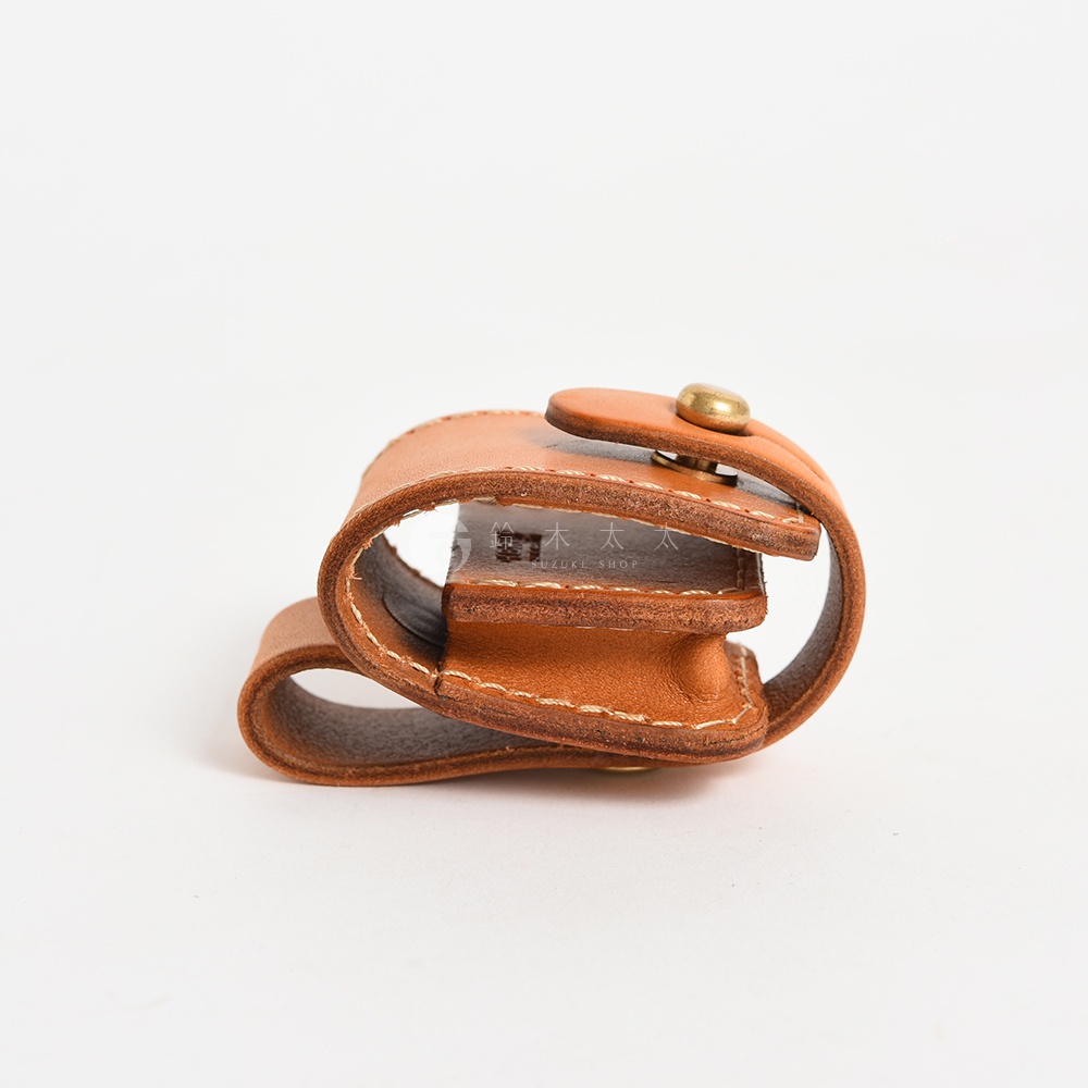 棕色皮革製作的腰間小物收納包，採用原子釦開合設計，縫線清晰，可見其多層結構。