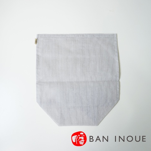 淺灰色蚊帳布製成的蔬果收納袋，材質透氣，袋口有標籤，底部呈錐形。