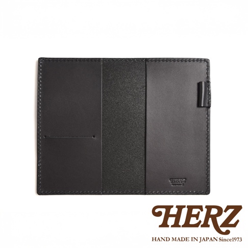 黑色皮革輕便記事本書套，內有插槽與筆套，皮革表面紋理細緻，邊緣縫線工整，品牌標誌壓印於內側。