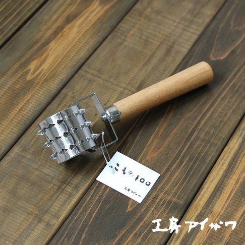 不鏽鋼滾輪斷筋器，具有木製手柄和圓柱形的不鏽鋼滾輪，滾輪表面佈滿尖銳的鋼釘。