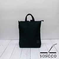 深綠色三河木綿刺子織手提後背包，織紋清晰，設有拉鍊開合及雙提把，右下方有同色系方形品牌標籤。