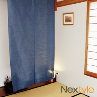 深藍色布製門簾，帶有細緻紋理，懸掛在日式房間門框上，旁邊有富士山裝飾畫與紙拉窗。