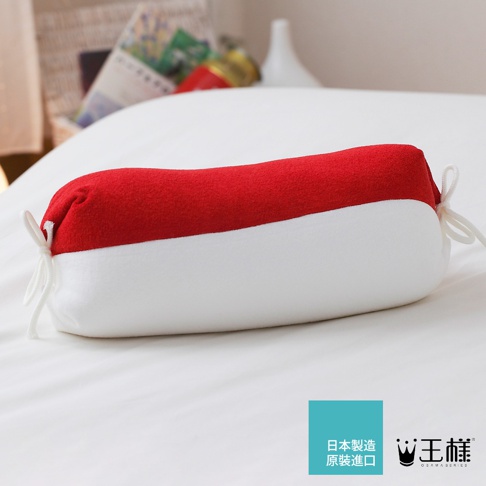 長條形糖果枕，上半部為紅色絨毛材質，下半部為白色柔軟材質，兩端有白色綁繩裝飾。