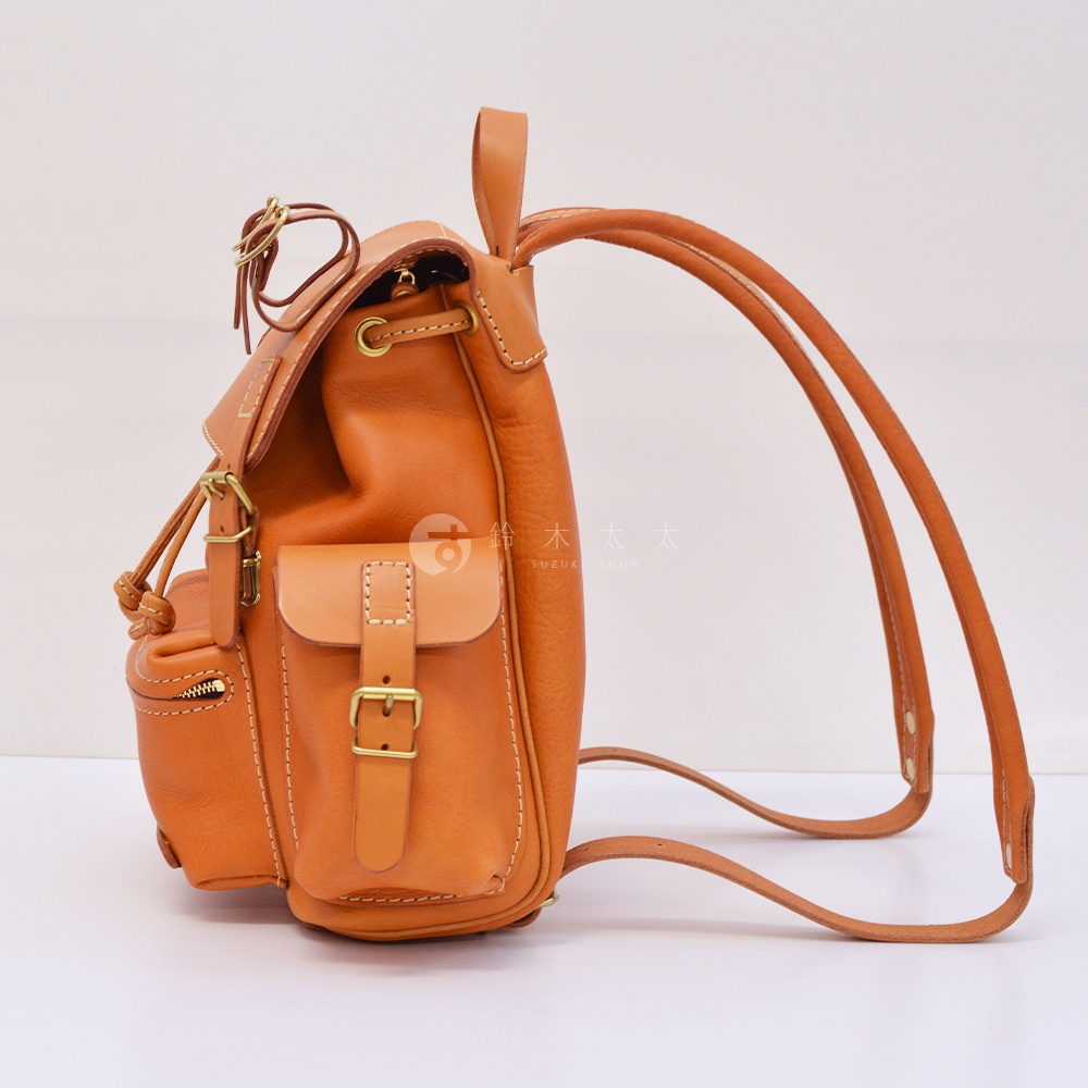 職人手作皮革復古風旅行後背包，採用天然棕色皮革製成，設有束口、翻蓋口袋、側邊拉鍊口袋及雙肩帶。