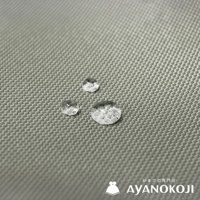 有三顆水珠落在米灰色機能布料上，布料表面有細密的編織紋理，右下角有日文及 AYANOKOJI 品牌標誌。