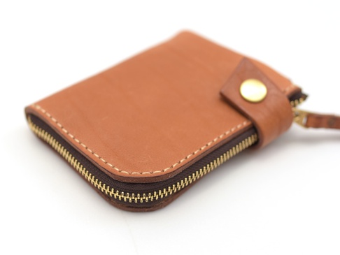 職人手作皮革獅鬃風拉鍊短夾，採用棕色皮革材質，搭配金色金屬拉鍊與按扣，車縫線清晰，質感良好，設計簡潔實用。