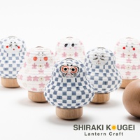 六個不同表情的達摩不倒翁迷你提燈，以白色紙質製作，印有藍色格子和粉色花朵圖案，底部為木製基座。