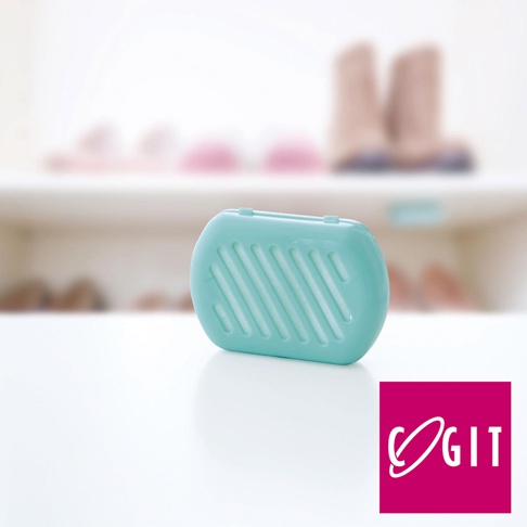 COGIT 品牌標誌旁的綠松石色長效除臭防霉鞋櫃用貼片盒，背景是模糊的鞋子。