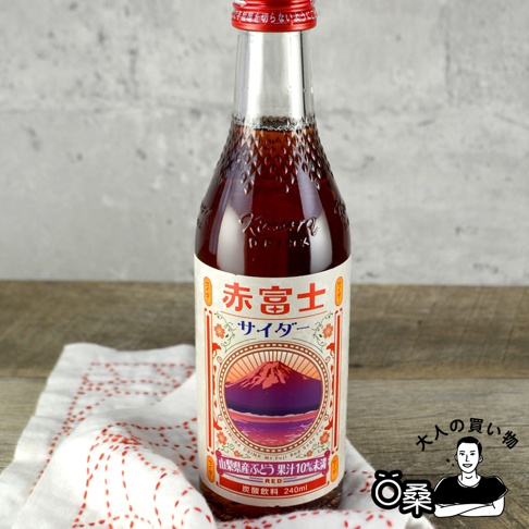 一瓶紅色的玻璃汽水瓶，瓶身印有「赤富士」字樣和富士山圖案，標籤為白色，有日文和英文說明，內容物為紅色液體，瓶蓋為紅色金屬材質。