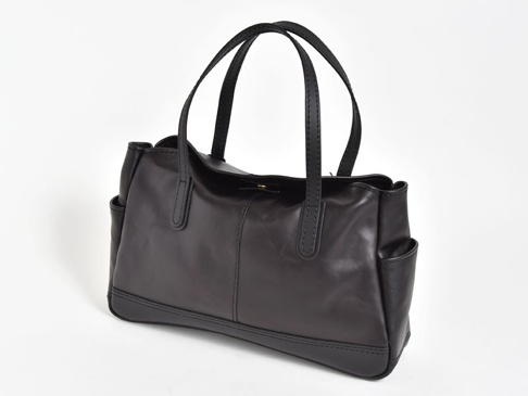 黑色皮革橫式肩背托特包，配有對稱縫線設計，兩側有外袋，頂部有提把。