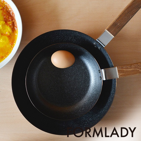 小泉誠 ambai 日製原木柄平底鐵鍋，18公分，黑色鐵鍋內有一顆淺褐色雞蛋，鍋柄為原木材質，連接處有銀色金屬。