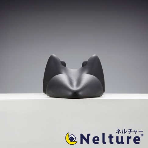 深灰色肩頸背拉伸牽引枕，採用人體工學設計，中央凹陷，兩側有向上彎曲的支撐，材質為柔軟有彈性的泡棉，用於支撐和伸展頸部。