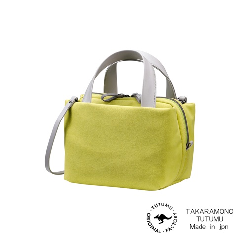 TUTUMU Suede tre tote 方形兩用托特包，黃綠色絨面材質，搭配淺灰色皮革提把和背帶，拉鍊開口，側邊印有TAKRAMONO TUTUMU Made in jpn 字樣及品牌標誌。