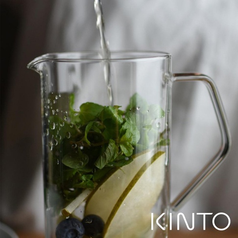 透明耐熱玻璃水瓶，內含新鮮薄荷葉、切片梨子與藍莓，正有水注入。