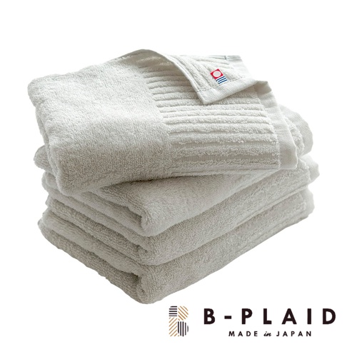 一疊白色今治長毛柔暖速乾直紋浴巾，頂部浴巾上有品牌標籤，材質柔軟，紋理清晰。