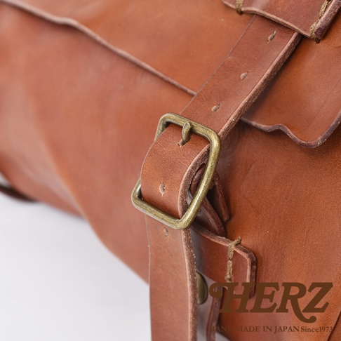 職人手作皮革水洗加工復古郵差包，呈現溫潤的棕褐色，包身材質為真皮，搭配復古風格的金屬釦具，質感細膩。