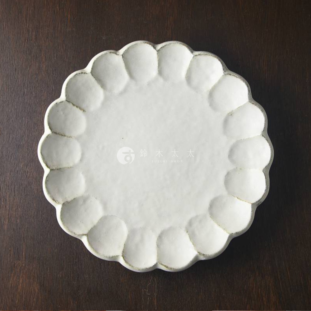 白色陶瓷主食盤，盤面有明顯的粉引釉色與六魯花型，邊緣帶有樸實的紋理。