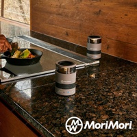 兩個灰色圓柱形無線藍牙音響，頂部有透明燈罩，內部有LED燈，下方有網狀揚聲器，品牌標誌印在音響中央。