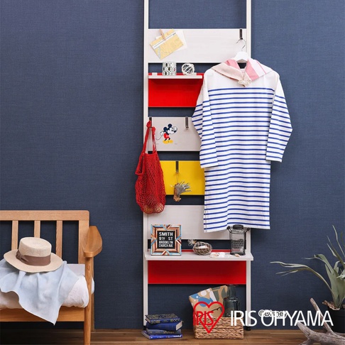 頂天立地木質收納架，白色框架搭配紅色與黃色層板，層板上掛有條紋洋裝、紅色網狀提袋，以及印有米奇圖案的掛畫。