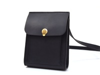 黑色厚實皮革單肩包，配有金色旋轉鎖扣和皮革肩帶。包身線條簡潔，縫線工整，整體呈現復古風格。