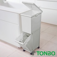 白色抗菌雙層分類附輪垃圾桶，上方為有蓋設計，下方為可抽出式收納盒，內有透明塑膠瓶，垃圾桶底部有四個小輪子。