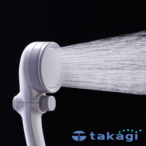 白色圓形蓮蓬頭，噴灑出細密水流，側邊有灰色開關，手柄為白色塑膠材質。