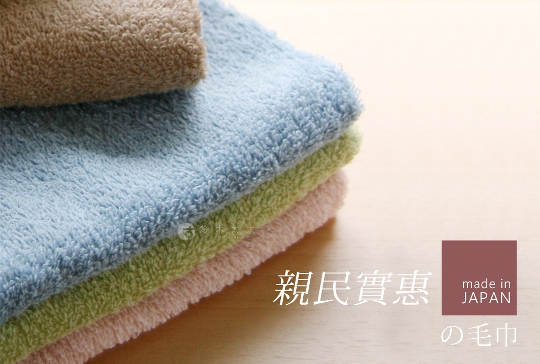 一疊由淺棕色、淺藍色、淺綠色和粉紅色毛巾組成的居家毛巾，材質柔軟，毛圈蓬鬆。