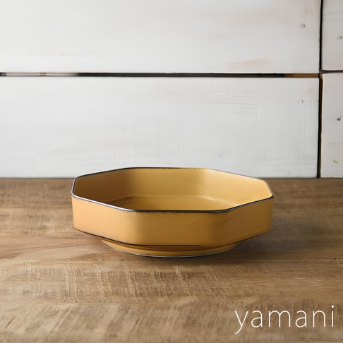 芥黃釉美濃燒八角盤，八邊形盤身，內側有細緻的黑色釉邊，盤底有座，整體呈柔和的芥黃色，散發溫潤質感。