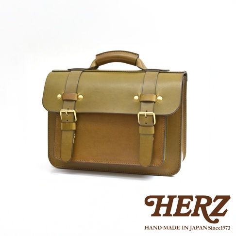 職人手作皮革經典雙扣兩用單肩包，採用兩種深淺不同的棕色皮革，配有黃銅色金屬扣件及雙扣設計，適合斜背或肩背。